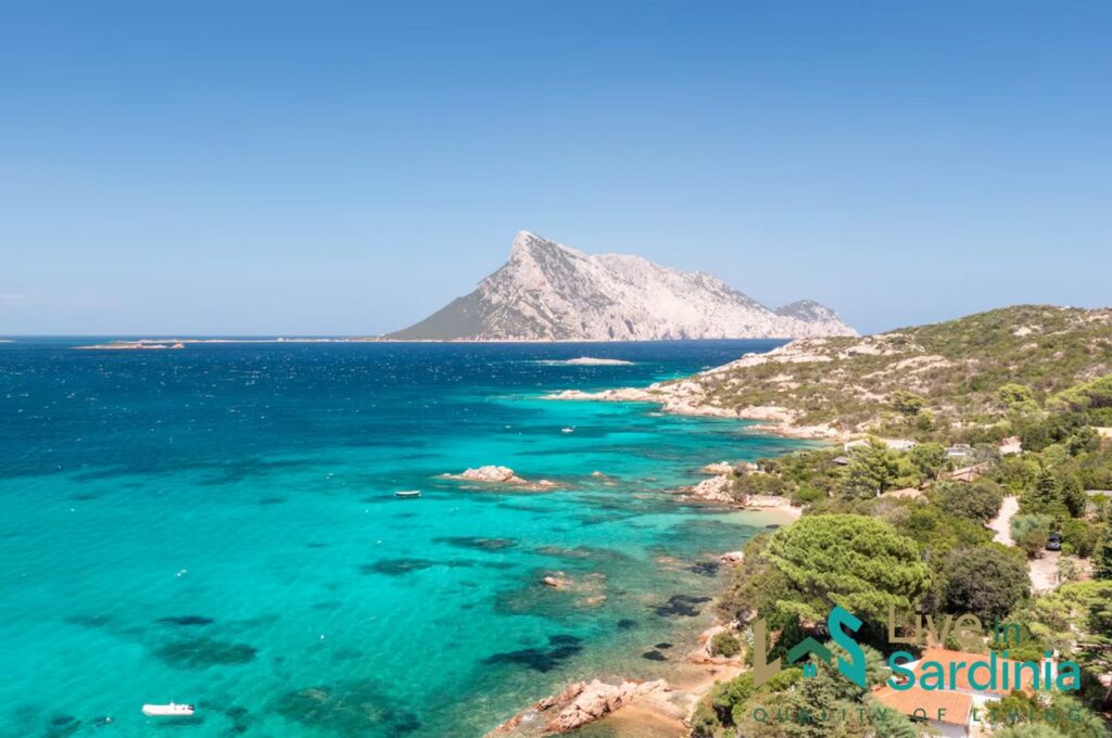 Aerial view on Tavolara Island across a turquoise hued sea water and rugged coastline 