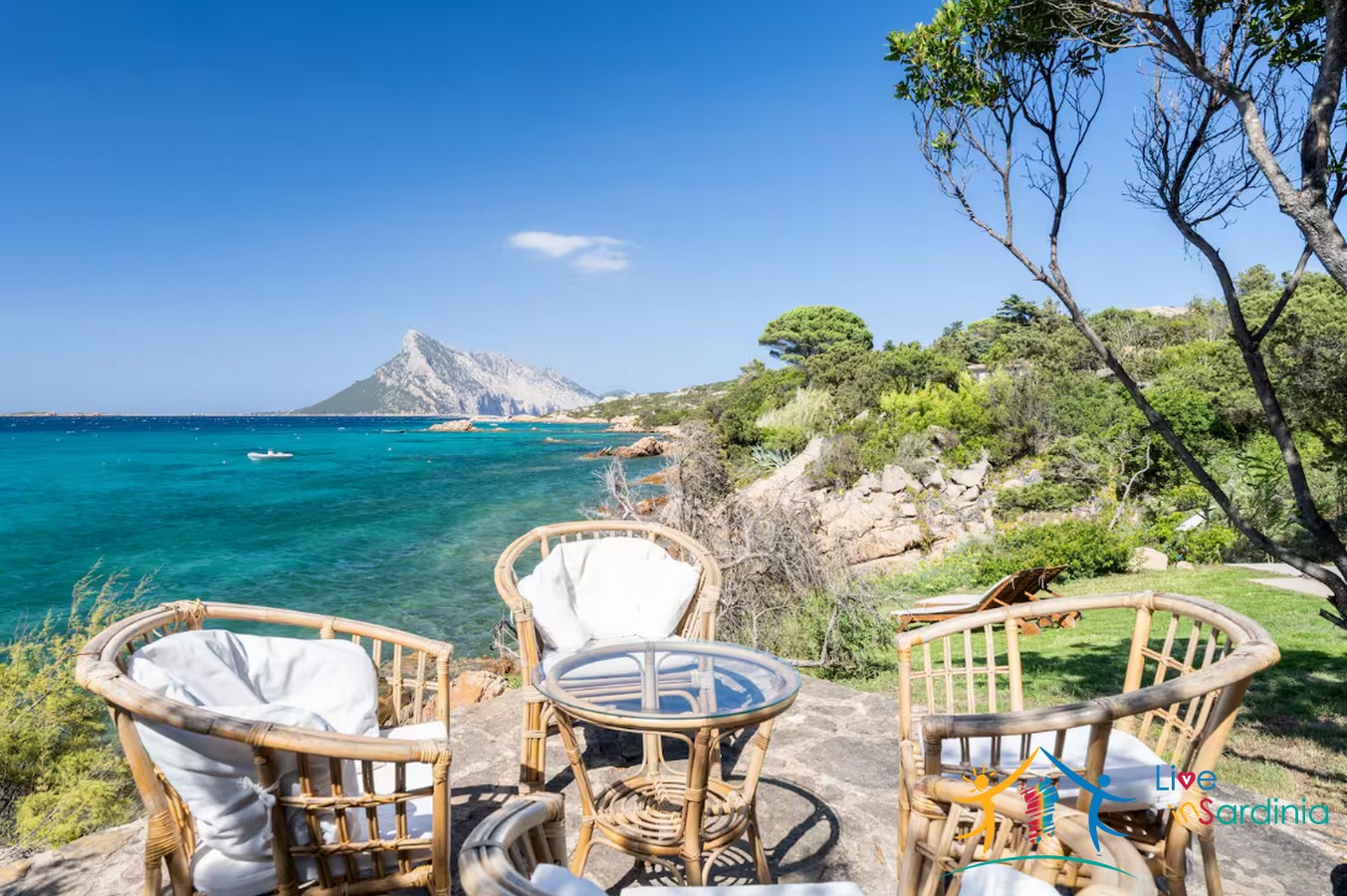 view on chair and table on a garden facing the sea and on the backdrop tavolare island 