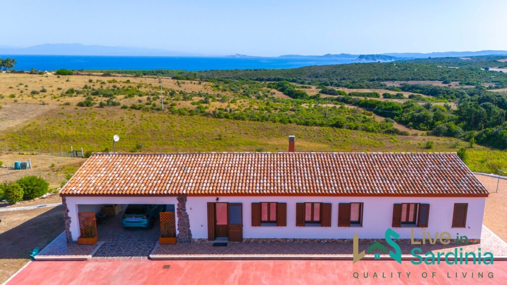 A bungalow home facing Sardinia coastline across a field