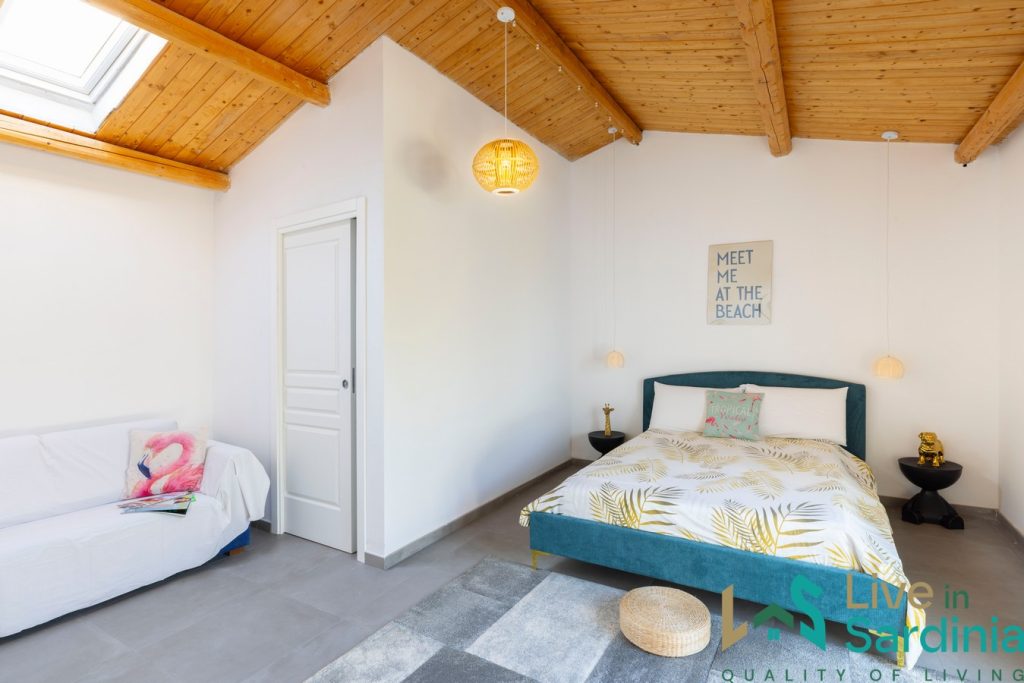 Sardinia home interior of a restored stazzu house, wooden ceilings and white painted walls in a modern, cosy living area