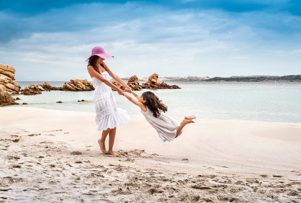 mother daughter playing on a sardinia beach