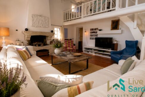 Traditional Gallurese country house living room with granite fireplace
